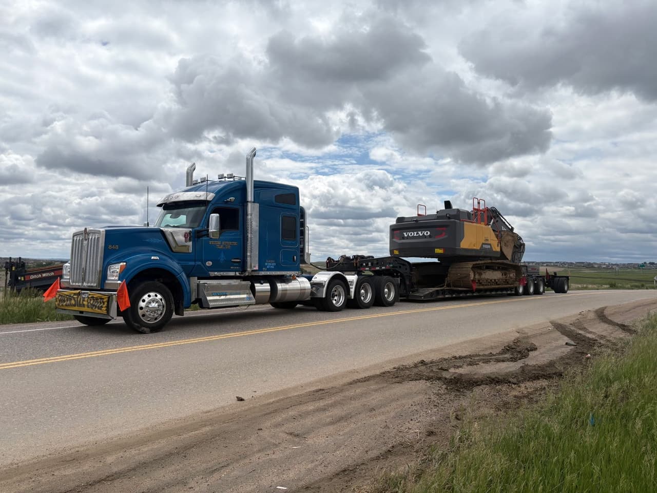 Western Towing Kenworth hauling a Volvo excavator on a lowboy