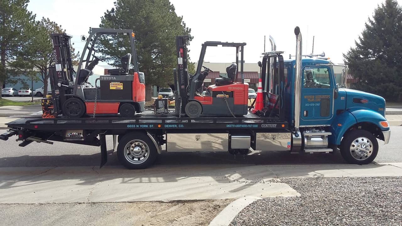 Western Towing rollback carrying two forklifts