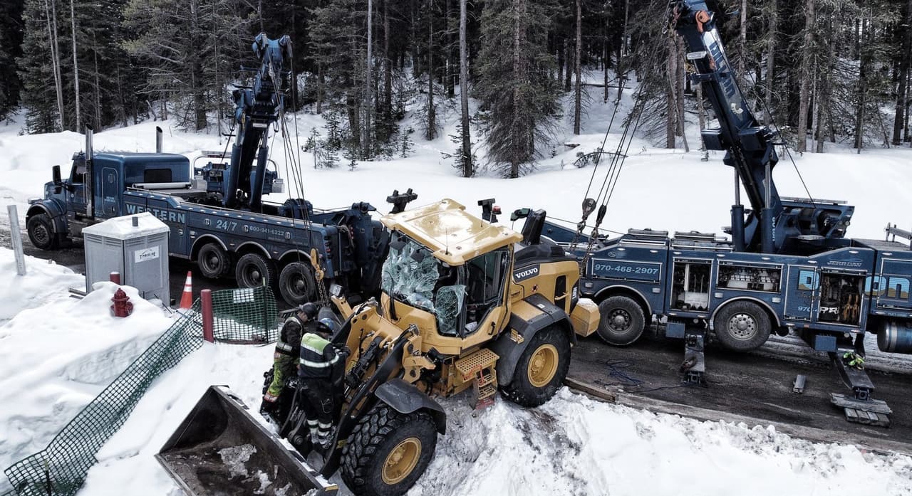 Two Western Towing rotators recovering a loader in deep snow